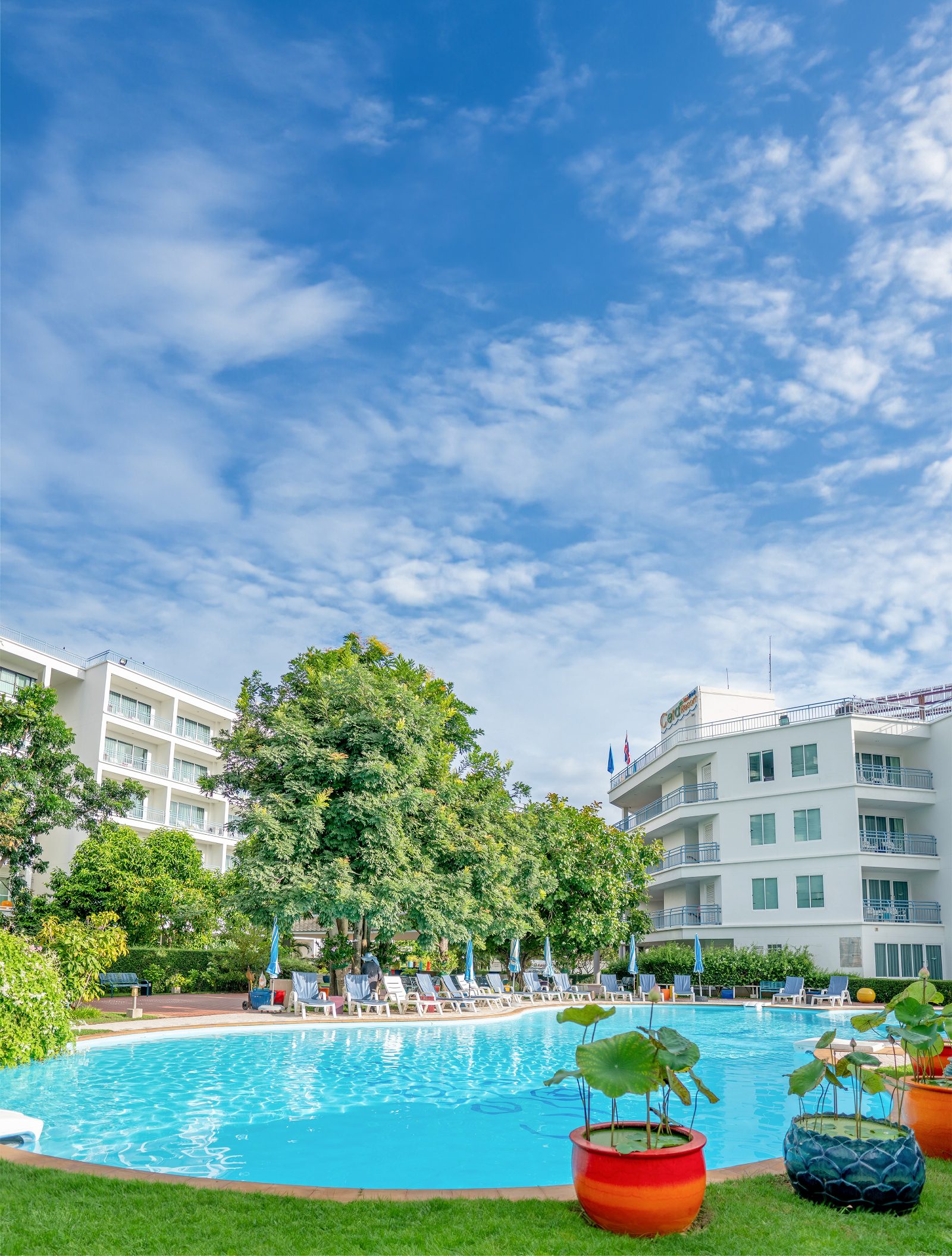 The pool and white resort buildings under blue sky