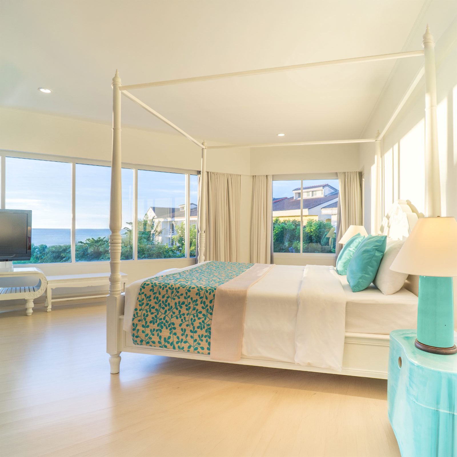 Bright white and turquoise suite with four-poster bed